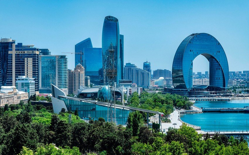 Panoramic view of Baku at night, featuring the illuminated Baku Boulevard, Caspian Sea, and iconic city landmarks